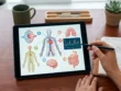 Tablet és füzet az asztalon, egészségügyi adatokkal